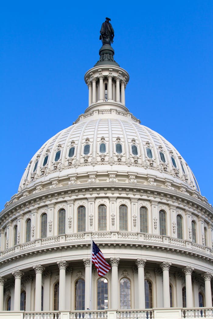 Close-up of the iconic dome of the United States Capitol building in Washington, DC against a clear blue sky.